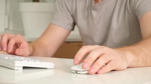 The man uses a keyboard and mouse. young man typing on computer keyboard Stock Footage 242298616