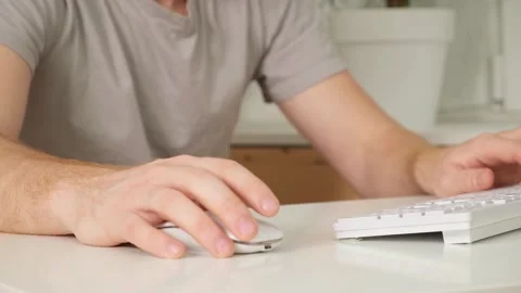 The man uses a keyboard and mouse. young man typing on computer keyboard Stock Footage 242444372