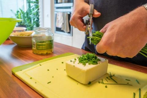 Man uses kitchen scissors to make herb butter Stock Photos