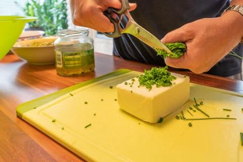 Man uses kitchen scissors to make herb butter Stock Photos