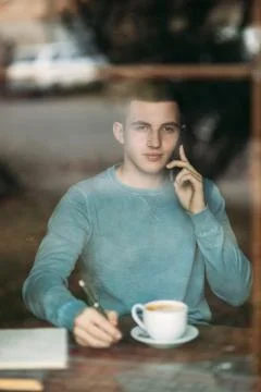 Man uses a laptop in a cafe while drinking coffee Stockfoto's