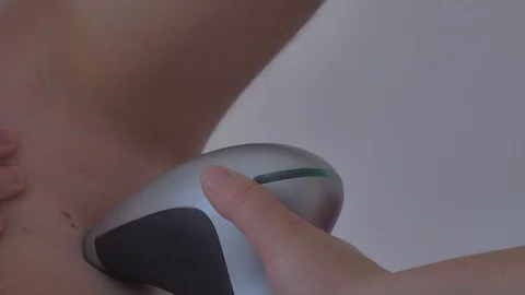 A man uses a laser epilator for epilation at home. Photoepilation of armpit. Video stock 112882357