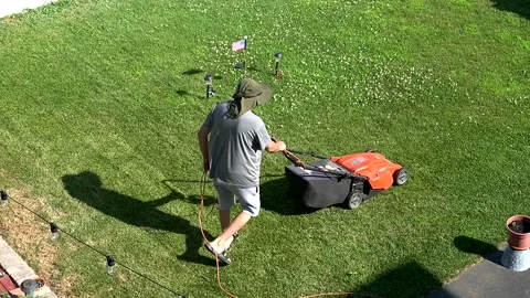 Man uses lawnmower to cut grass Revere Mass. USA July 3 2025 Stock Footage 314855159