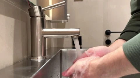 A man uses liquid soap to wash his hands and then washes his hands in warm water Stock Footage 306124617