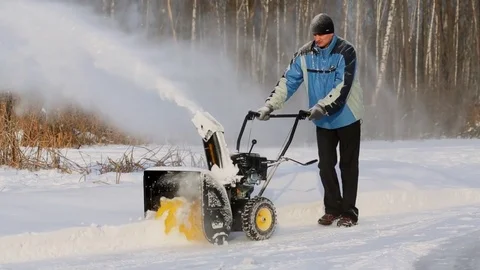 Man uses machine with petrol engine for remove snow at winter day Stock Footage 74453897