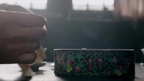 The man uses a match to light the paper in his hand Stock Footage 276517780