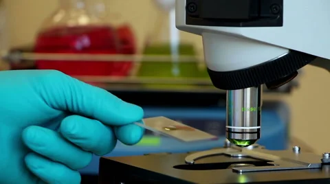 A man uses microscope on the colorful background Stock Footage 63614021