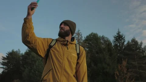 A man uses a mobile phone to find GPS and navigate in the mountains. Stock Footage 220188979