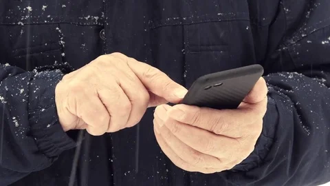 Man Uses A Mobile Phone On Snowfall In The Forest Stock Footage 85242572