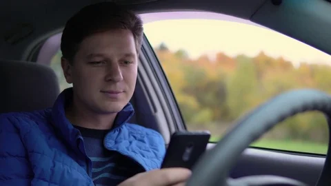 A man uses a mobile phone while driving a car. Stock Footage 81233184