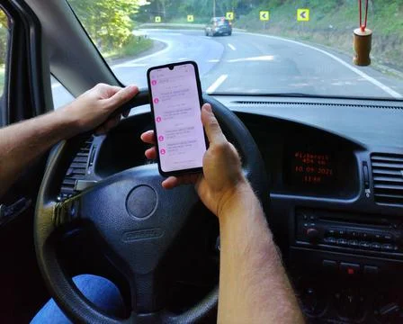 A man uses a mobile phone while driving a car Stock Photos