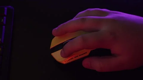 A man uses a mouse, clicks on buttons, plays a game, or works under a neon light Stock Footage 132537668