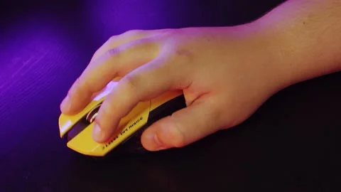 A man uses a mouse, clicks on buttons, plays a game, or works under a neon light Stock Footage 132537682