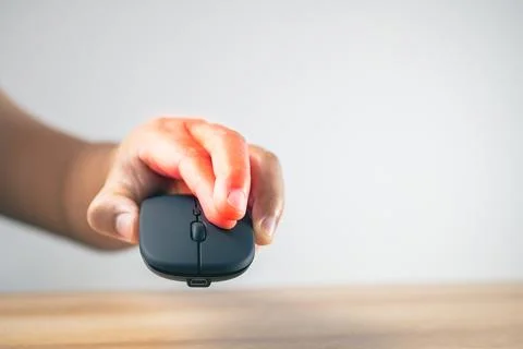 The man uses a mouse until his fingers pain. Office syndrome concept. Pain sy Stock Photos