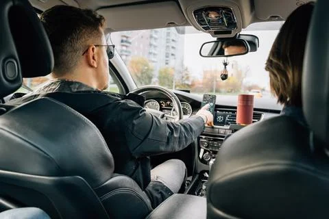 A man uses a navigator application in a mobile phone while driving and drivin Stock Photos