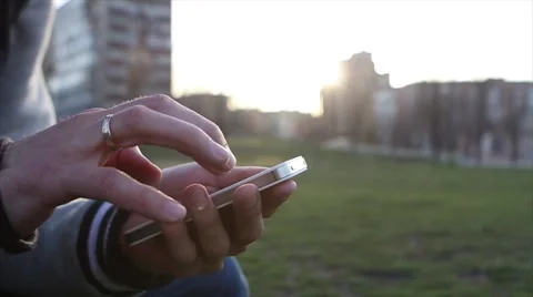 Man Uses The Ohone At a Sunset Background Stockbeeldmateriaal 64874023