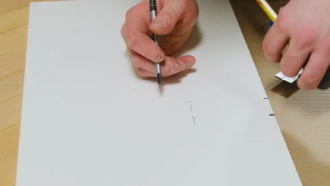 Man uses pencil to draw precise marks on white board Stock Footage 304401675