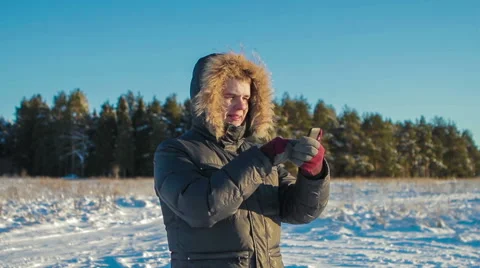 Man Uses Phone on Background of Winter Forest Video stock 62284397