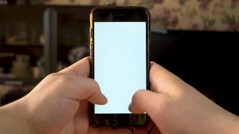 The man uses the phone. Hands is typing on smartphone with white screen Stock Footage 127059677