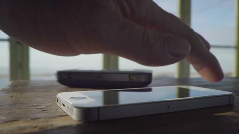 Man uses phone, iphone, in a fire lookout cabin with cell phone wifi Stock Footage 96221834