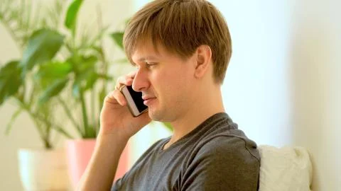 The man uses a phone for remote work during self-isolation. 스톡 사진