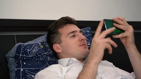 A man uses the phone while lying on the couch and is emotionally indignant Stock Footage 167157267