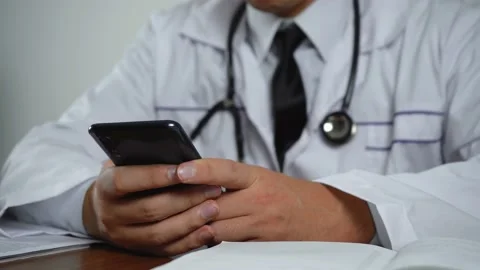 The man uses the phone while sitting at the table Stock Footage 145248011