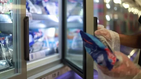 Man uses plastic bags as protective gloves at the supermarket due to COVID-19. Stock Footage 133369030