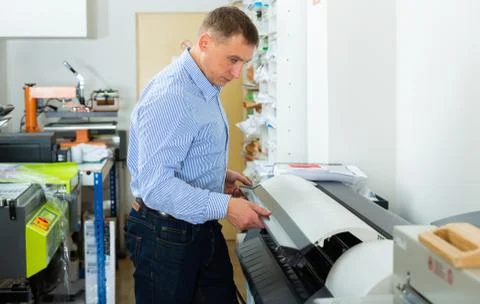 Man uses plotter in small printing shop Stock Photos