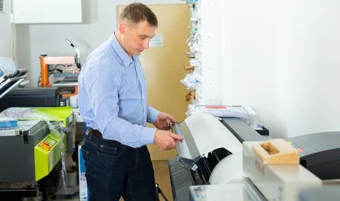Man uses plotter in small printing shop Stock Photos