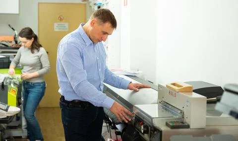 Man uses plotter in small printing shop 写真素材