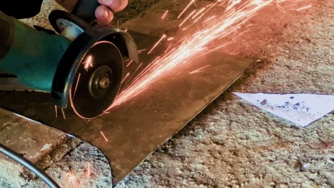 A man uses a power tool to cut metal Stock Footage 315340285