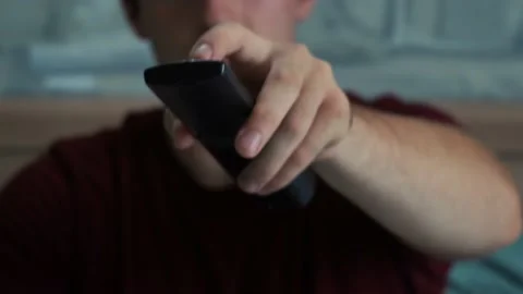 Man uses the remote while sitting in front of the TV Stock Footage 161616389