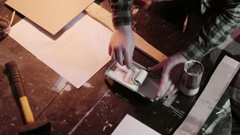 Man uses Roller to priming the protest banner in domestic atmosphere Stock Footage 143348613