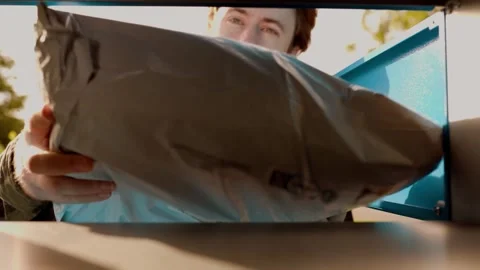 Man uses a self-service terminal for contactless delivery. He opens the parcel l 库存影片 339273556