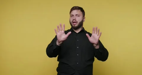 Man uses sign language to communicate in front of a yellow background durin.. Video stock 326789793