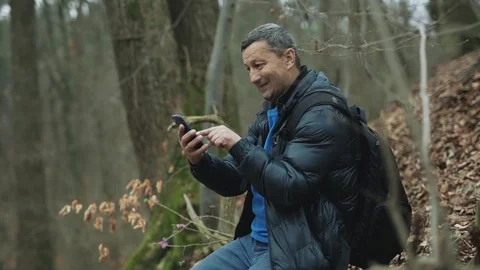 A man uses smarphone in the spring forest smile feel happy technology park Stock Footage 127168419