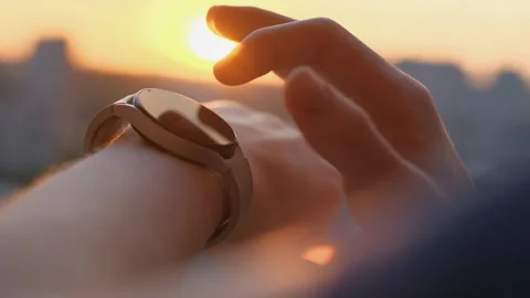 A man uses a smart watch at sunset, close-up Video stock 274361795