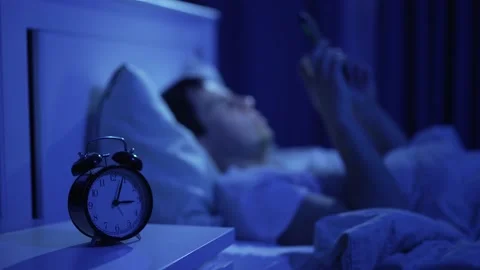 Man uses smarthone in a bed Stock Footage 165348054