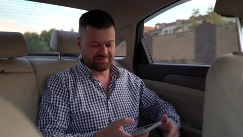 A man uses smartphone in the back seat of a taxi Stock Footage 204097439