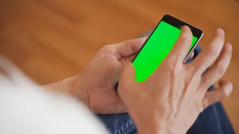 A man uses a smartphone with a green screen. 4K chroma key Stock Footage 128000088