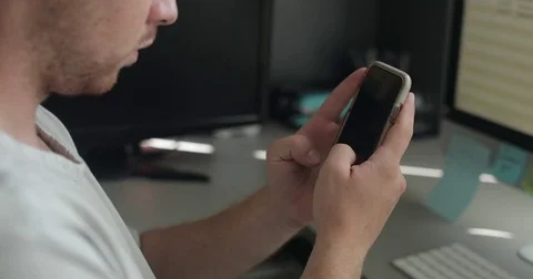 Man uses smartphone in home office Stock Footage