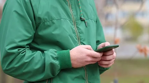 A man uses a smartphone surf the Internet on the street. Stock Footage 164566414