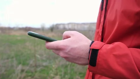 A man uses a smartphone surf the Internet on the street. 库存影片 180759243