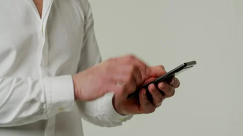 A man uses a smartphone, types text deftly and quickly. A businessman makes an Stock Footage 252880890