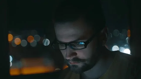 A man uses a smartphone by the window at night. Video stock 238434552