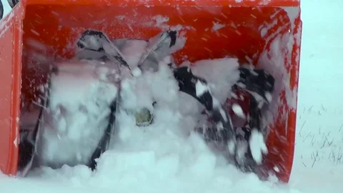 A man uses a snowblower in a winter storm while his neighbors shovel snow. Stock Footage