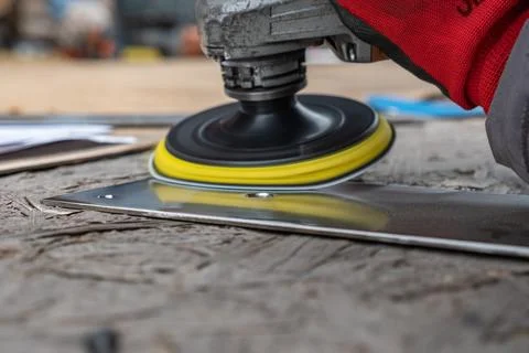 A man uses a special tool to grind metal in a workshop. Interior of a heavy mach Stock Photos