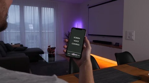 Man uses speech recognition smartphone app to turn on a screen in his Stock Footage 123114811