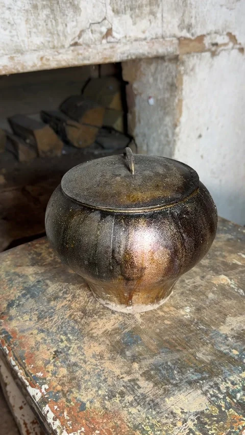 A man uses a stove hook to remove a cast iron pot from the stove. He takes .. Video stock 327554080